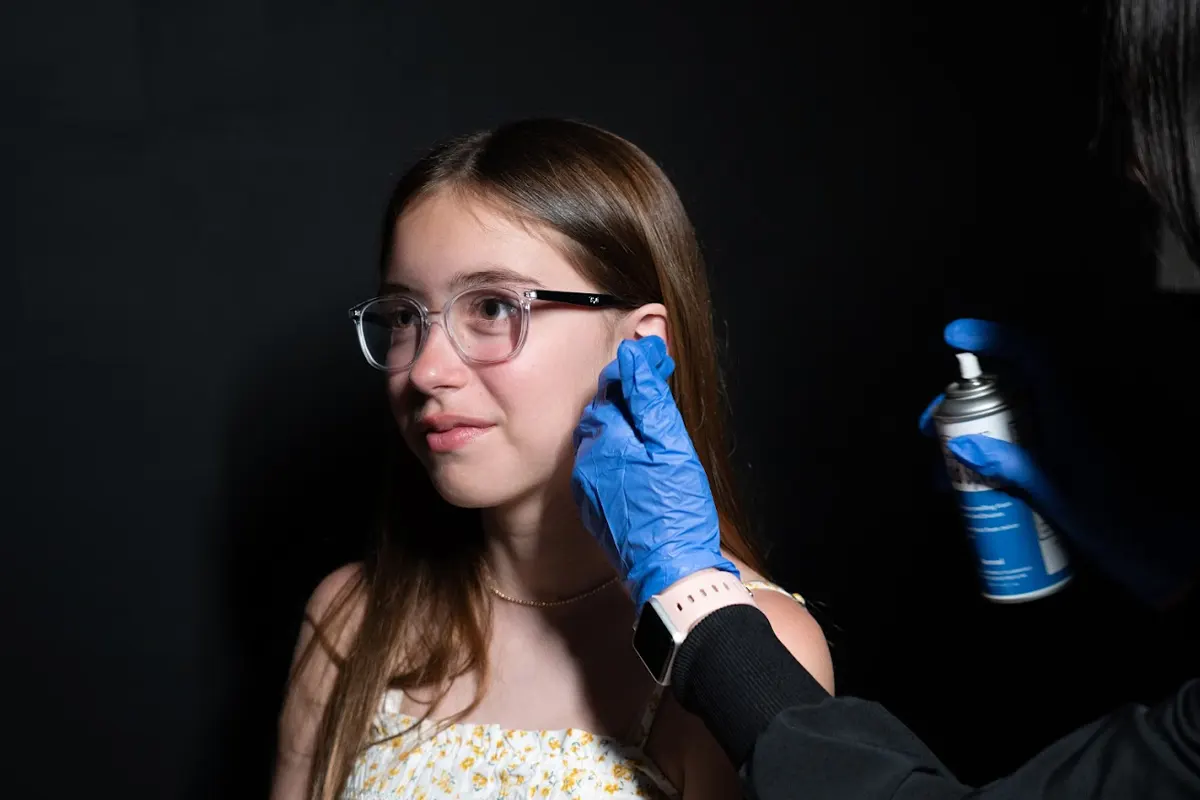 Clinician sanitizing a child’s ear before gentle ear piercing at Express Med Spa Mount Greenwood