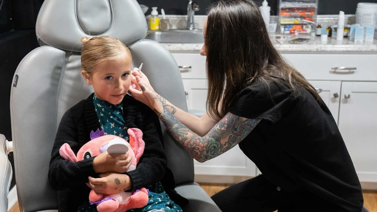 Child having ears pierced professionally with sterile technique at Express Med Spa in Manteno, IL