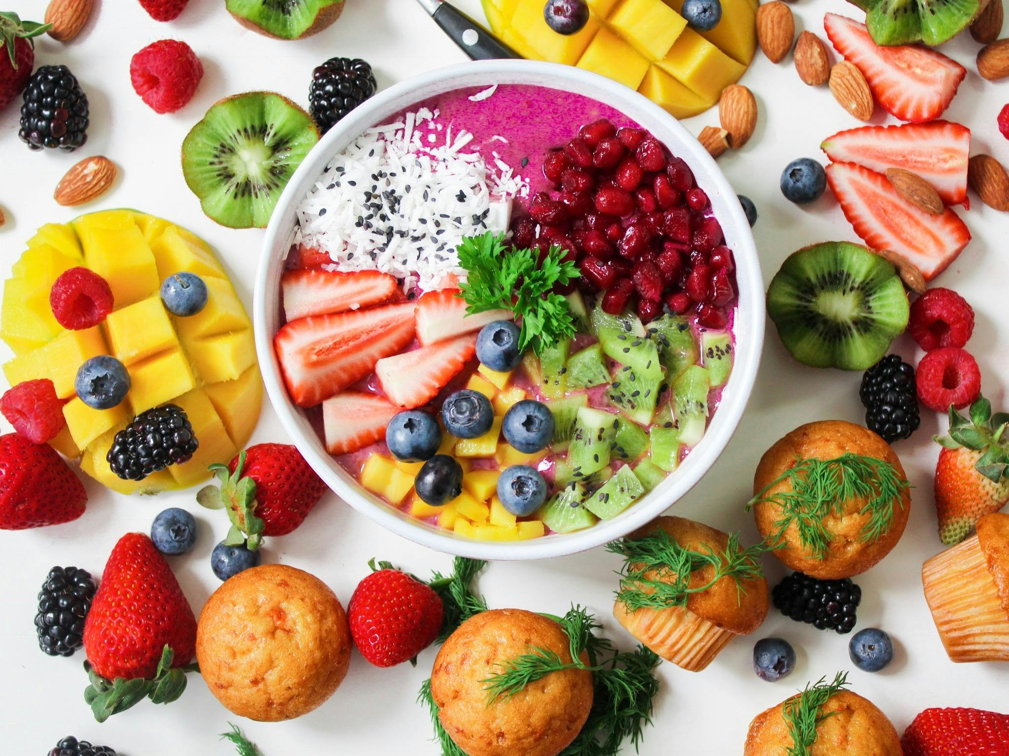 Colorful smoothie bowl with berries, kiwi, mango, and almonds—promoting skin health and wellness