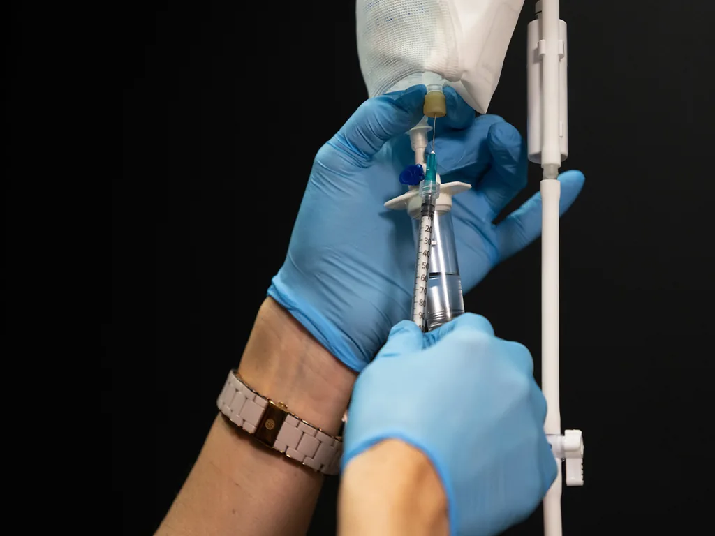 Nurse practitioner priming an intravenous infusion line at Express Med Spa, the delivery method used for NAD+ IV therapy