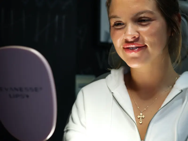 Smiling woman admiring her fuller lips in the mirror after Versa Lip Filler at Express Med Spa La Grange IL